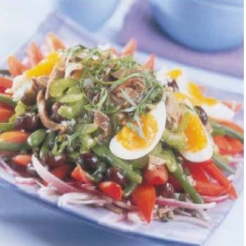 salade nioise sur une assiette carre de couleur blanche
