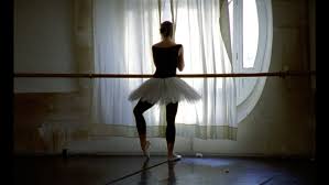 Danseuse en tutu de dos, face  une fentre  l'Opra de Paris.; La photo est lgrement sombre