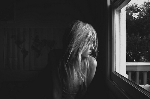 image décorative en début de chapitre - photo d'une jeune femme de profil, regardant par la fenêtre